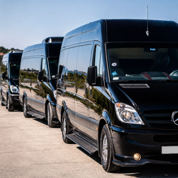 A fleet of modern black transport vans lined up, illustrating the Odoo vehicle tracking and shuttle logistics management software for Moroccan tourism transport operators.